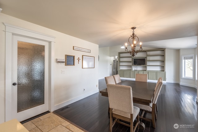 dining room with a notable chandelier and dark hardwood / wood-style floors