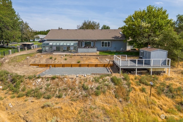 rear view of property with a shed and a wooden deck