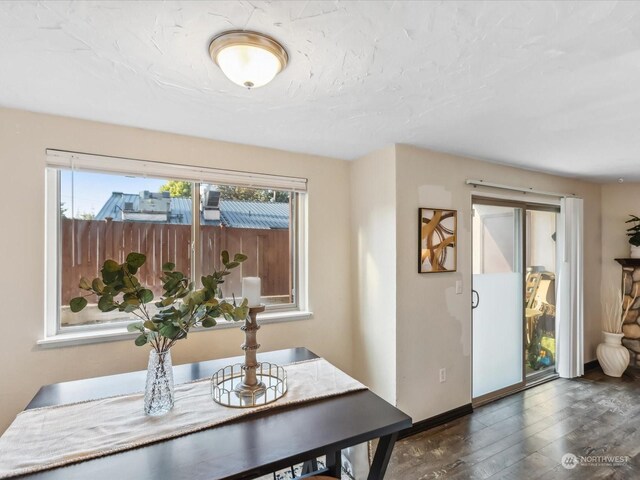 dining area featuring dark wood finished floors and baseboards