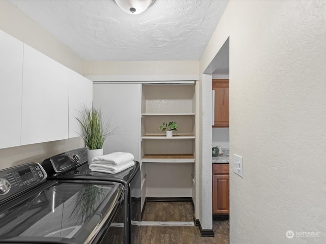 laundry area with a textured ceiling, cabinets, independent washer and dryer, and dark hardwood / wood-style floors