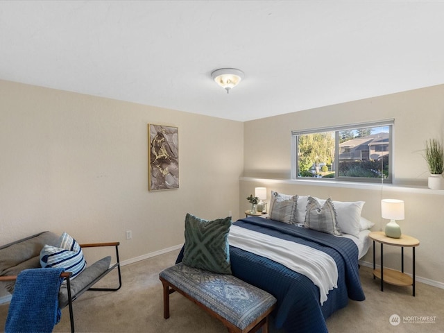 bedroom featuring light carpet and baseboards