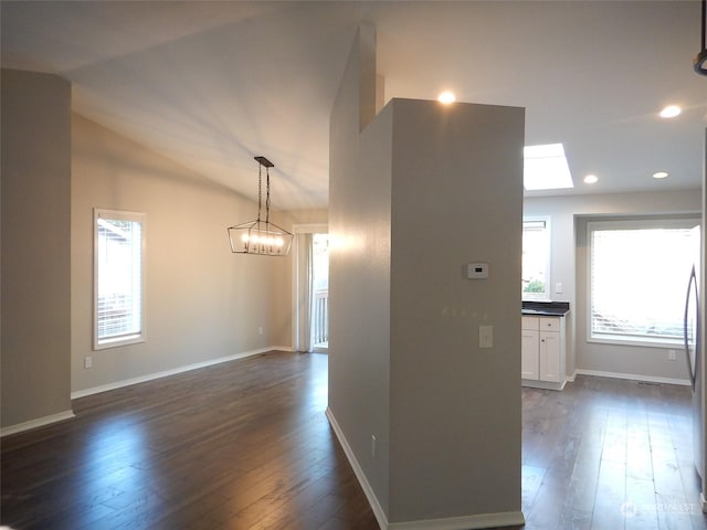 spare room with dark wood-type flooring, recessed lighting, vaulted ceiling, and baseboards