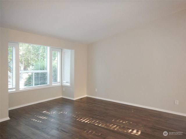 unfurnished room featuring dark wood finished floors and baseboards