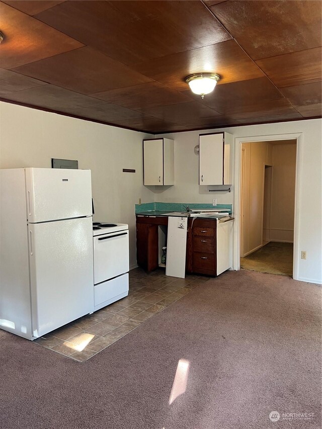 kitchen featuring white appliances, carpet, and white cabinetry