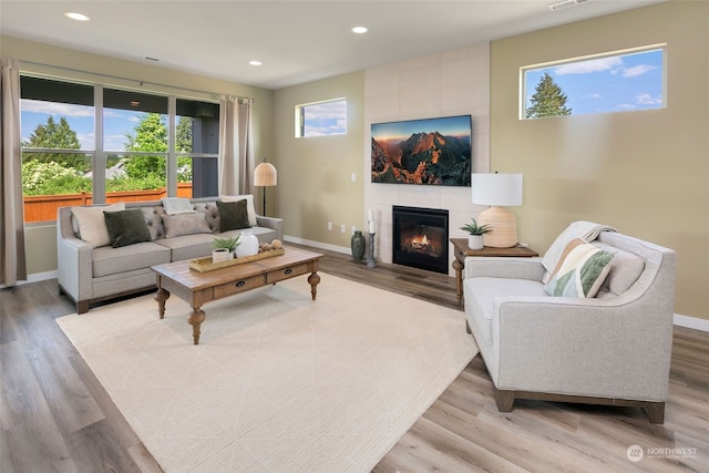 living room featuring light hardwood / wood-style floors and a tile fireplace