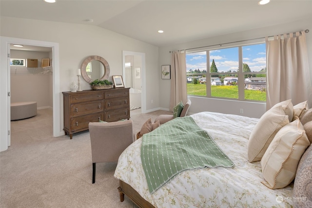 bedroom featuring light colored carpet, a closet, a walk in closet, and vaulted ceiling