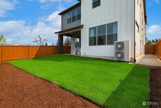 back of house with ac unit and a yard