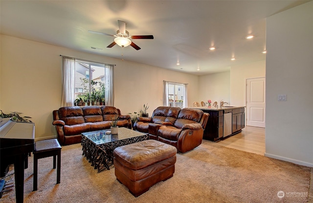 living room with ceiling fan, light hardwood / wood-style floors, and sink