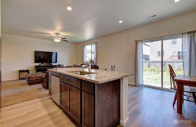 kitchen with light hardwood / wood-style flooring, sink, ceiling fan, a kitchen island with sink, and stainless steel dishwasher