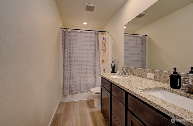 full bathroom featuring vanity, toilet, wood-type flooring, and shower / tub combo