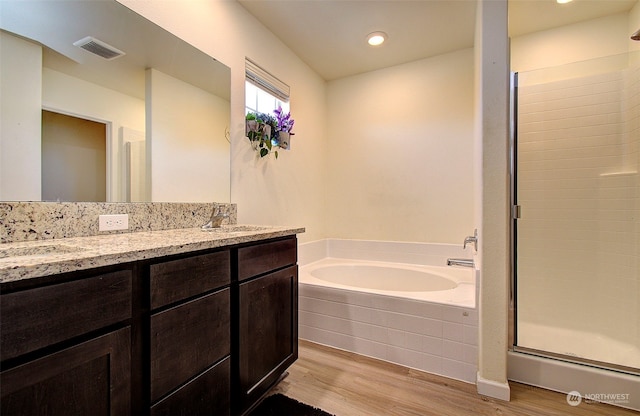 bathroom featuring plus walk in shower, hardwood / wood-style floors, and vanity