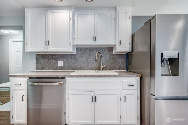 kitchen with hardwood / wood-style flooring, sink, stainless steel appliances, and white cabinets