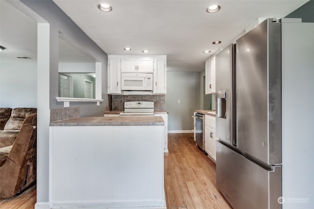 kitchen with light hardwood / wood-style flooring, stainless steel appliances, white cabinets, and backsplash