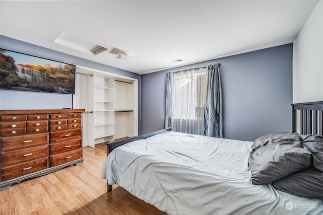 bedroom with light hardwood / wood-style flooring and a closet