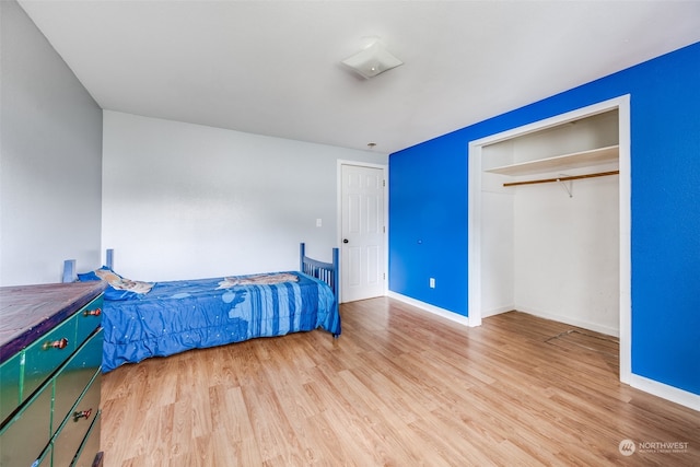 bedroom with a closet and light hardwood / wood-style floors