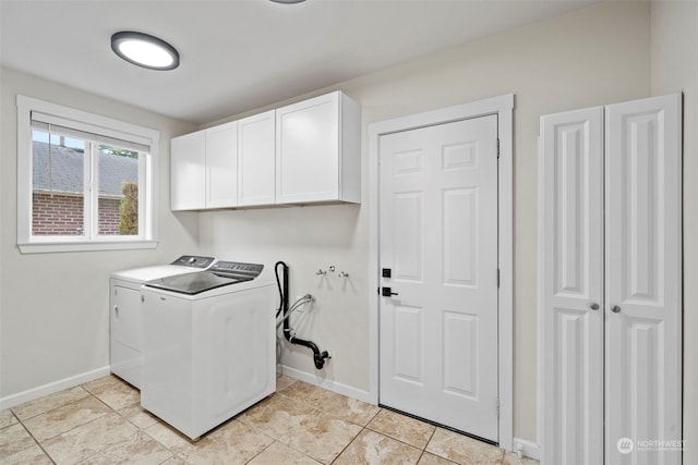 laundry area featuring washing machine and clothes dryer, cabinets, and light tile patterned flooring