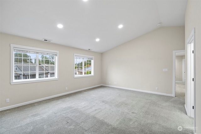 carpeted spare room featuring lofted ceiling