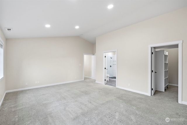 carpeted empty room featuring vaulted ceiling