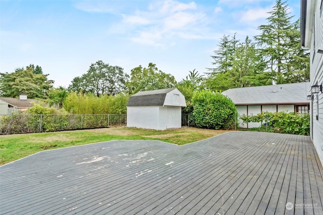 deck featuring a storage unit and a yard