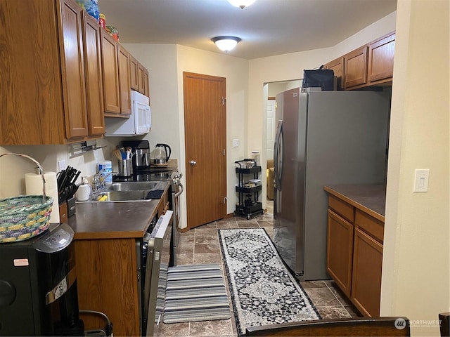 11714 9th Avenue Ct E, Tacoma, WA 98445 - kitchen with a sink, stone finish flooring, dark countertops, stainless steel appliances, and brown cabinetry