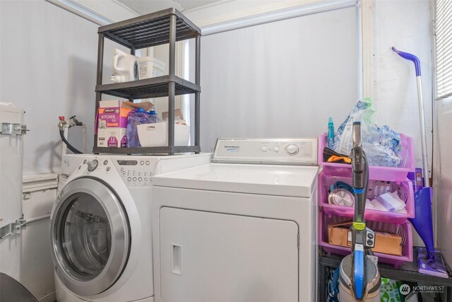 clothes washing area featuring crown molding and washing machine and dryer