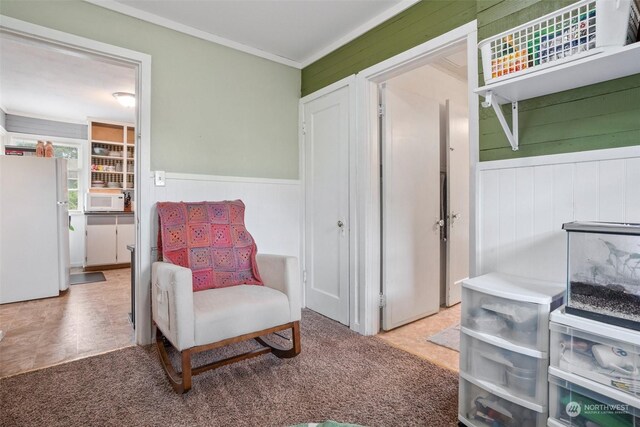 sitting room with crown molding and light carpet