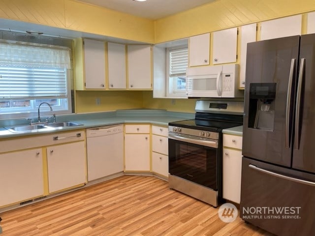 205 Monroe St, Ryderwood, WA 98581 - kitchen featuring light wood finished floors, stainless steel appliances, light countertops, a sink, and white cabinetry