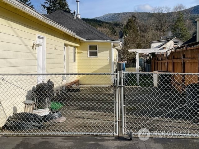 205 Monroe St, Ryderwood, WA 98581 - view of property exterior featuring fence, a gate, and a mountain view