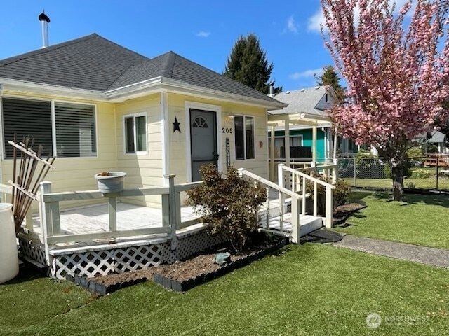 205 Monroe St, Ryderwood, WA 98581 - bungalow-style house with fence, a deck, a shingled roof, and a front yard