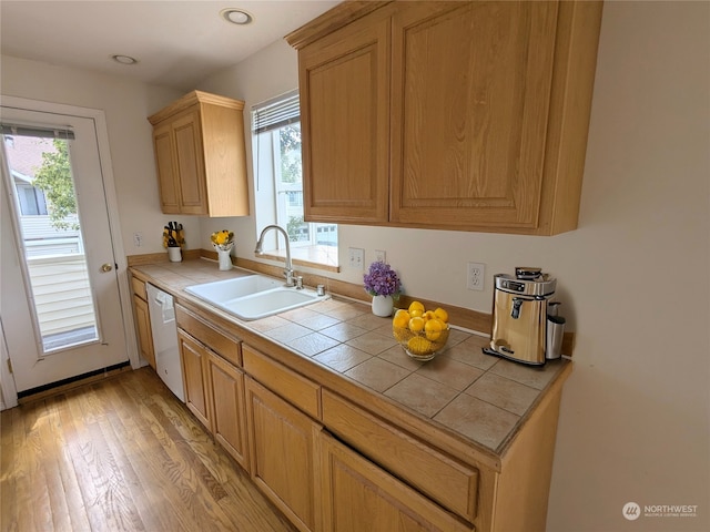 kitchen featuring tile countertops, sink, white dishwasher, and light hardwood / wood-style floors