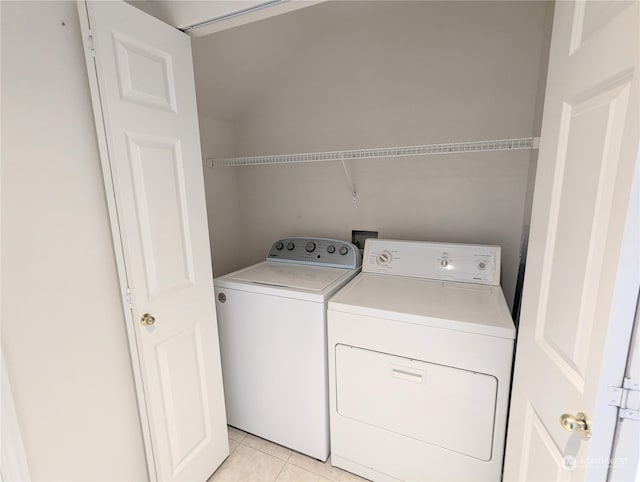 laundry room with washer and clothes dryer and light tile patterned floors