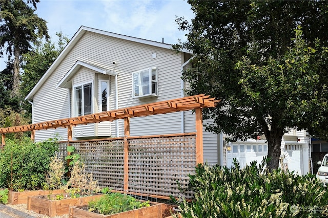 view of front facade featuring a garage and a pergola