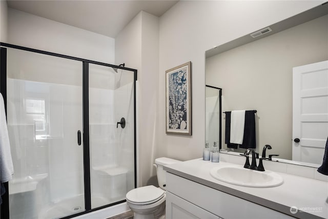 bathroom featuring an enclosed shower, vanity, and toilet