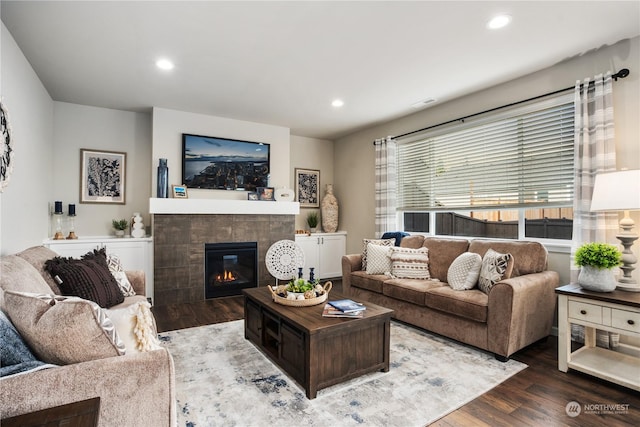 living room featuring hardwood / wood-style flooring and a tiled fireplace