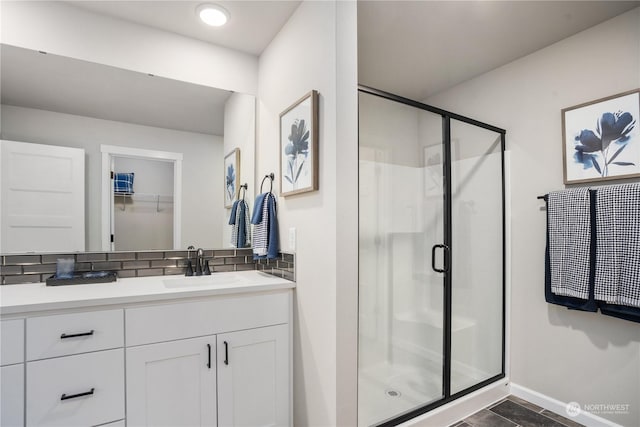 bathroom featuring a shower with door, vanity, decorative backsplash, and tile patterned flooring