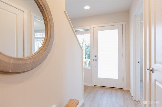 doorway to outside featuring light wood-style floors, a healthy amount of sunlight, baseboards, and recessed lighting