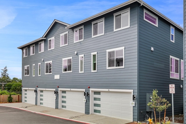 view of front of house with a garage and fence