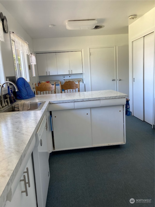 kitchen with dark carpet, dishwasher, kitchen peninsula, sink, and white cabinets