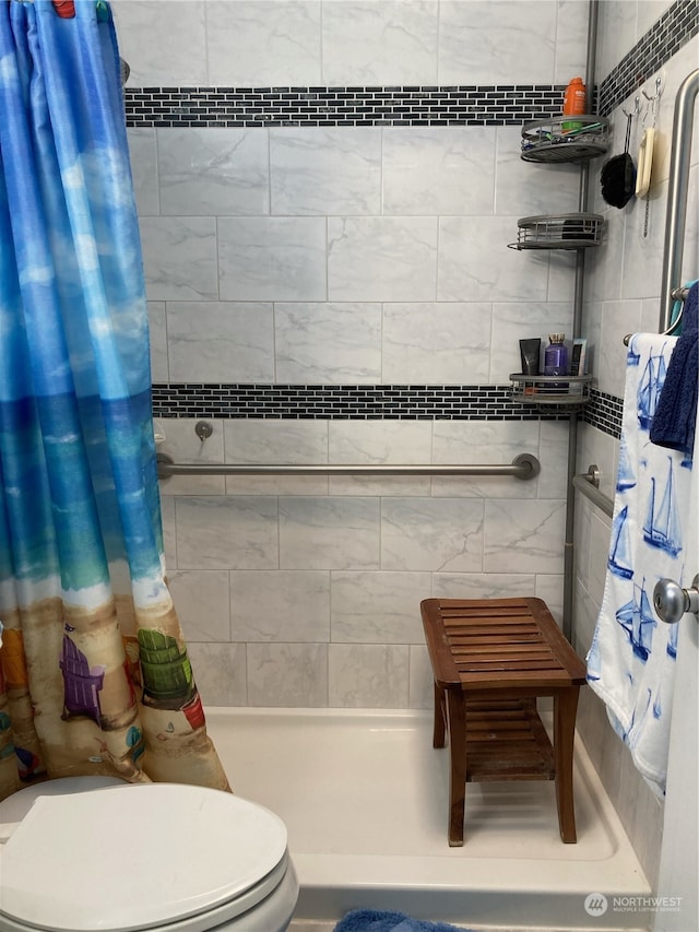 bathroom with a shower stall and toilet