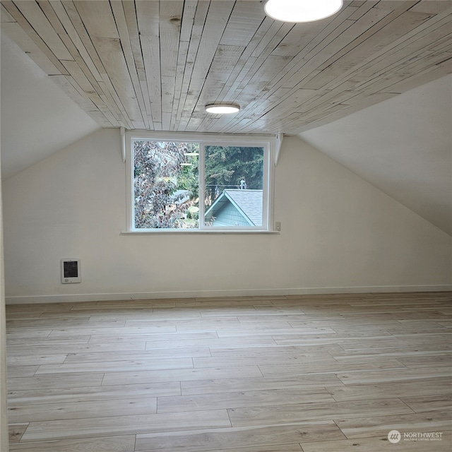 additional living space with light wood-type flooring, heating unit, wooden ceiling, and vaulted ceiling