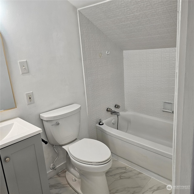 full bathroom featuring tiled shower / bath, vanity, and toilet