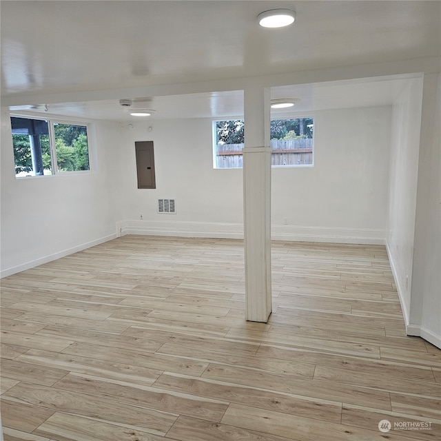 basement with light wood-type flooring and a healthy amount of sunlight