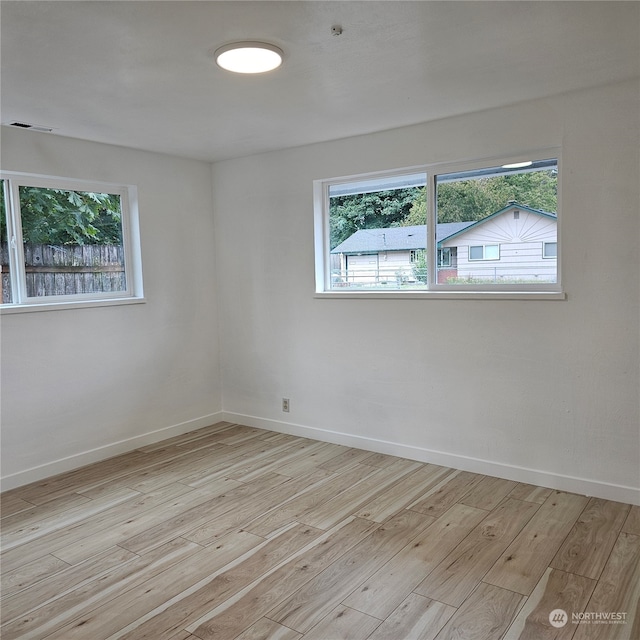 unfurnished room featuring a wealth of natural light and light hardwood / wood-style floors