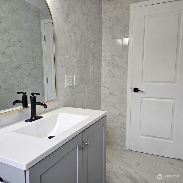 bathroom featuring vanity and tile walls