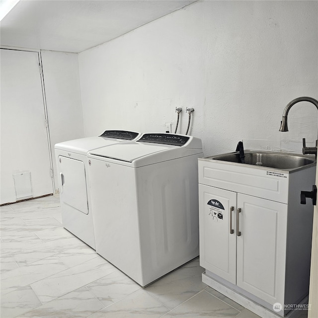 washroom featuring washer and dryer, cabinets, and sink