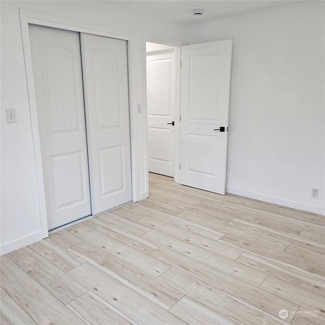 unfurnished bedroom featuring a closet and light hardwood / wood-style flooring