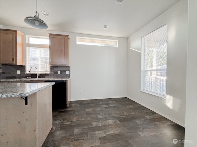 kitchen featuring tasteful backsplash, decorative light fixtures, dark hardwood / wood-style flooring, sink, and a breakfast bar area