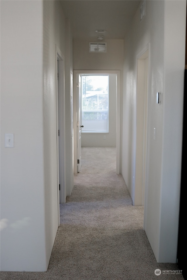 hall with light colored carpet