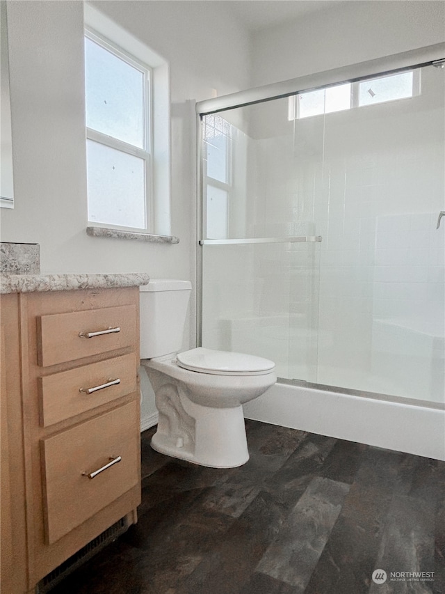 bathroom featuring an enclosed shower, toilet, a wealth of natural light, and vanity