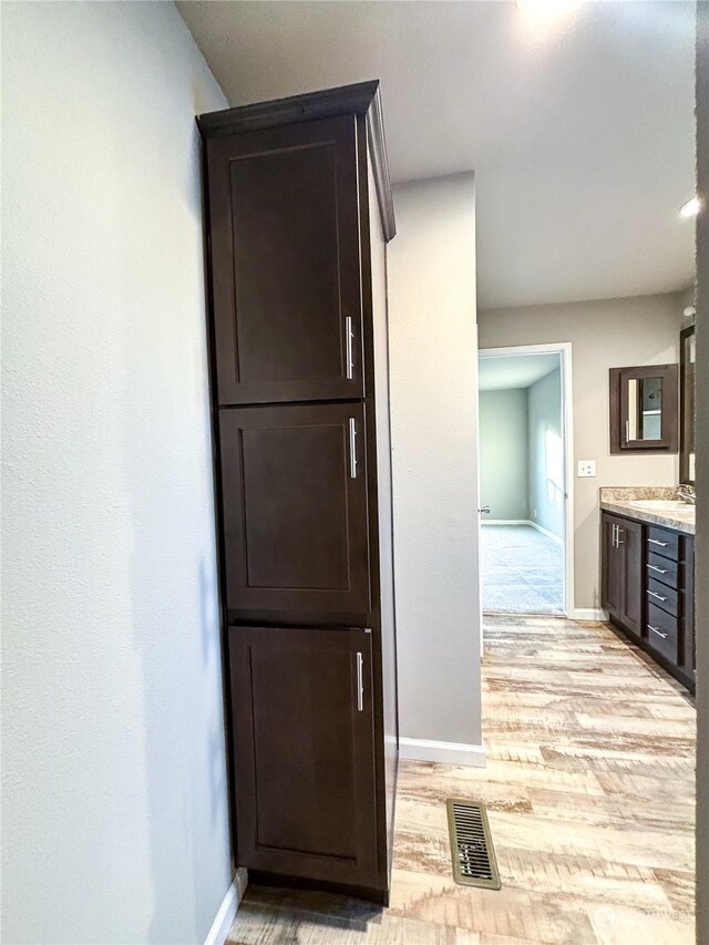 1223 Jones Dr, Walla Walla, WA 99362 - hall featuring light wood finished floors, visible vents, baseboards, and a sink